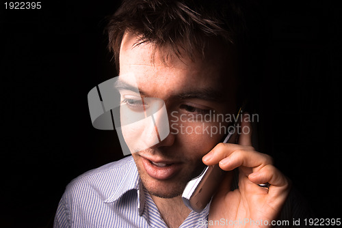 Image of Young man talking on cell phone