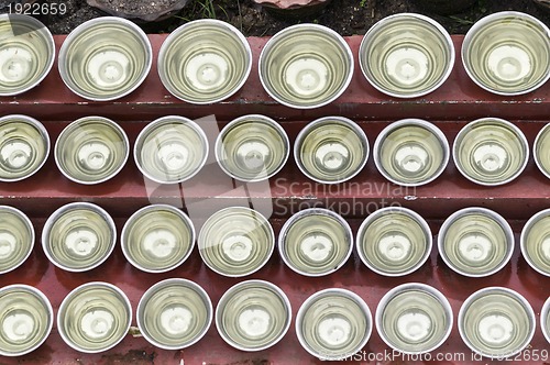 Image of small bowls with water around a temple