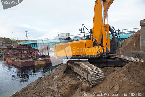 Image of Excavator builds a bridge.