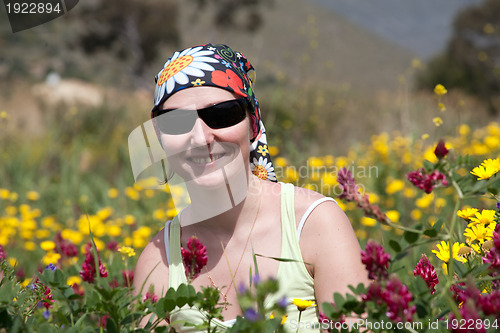 Image of portrait of woman among summer wild flowers