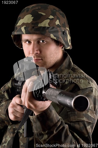 Image of Watchful soldier aiming  m16 in studio