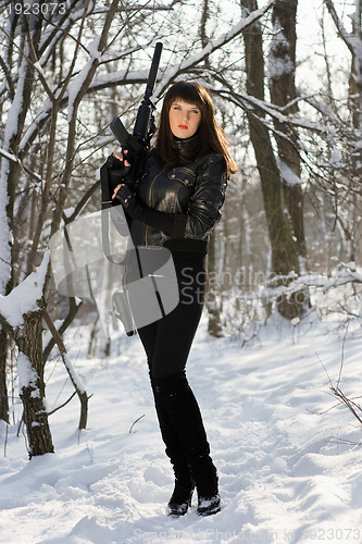 Image of woman with a rifle in winter forest