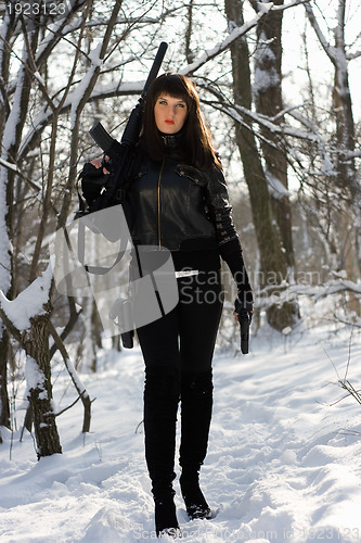 Image of young woman with a rifle and pistol