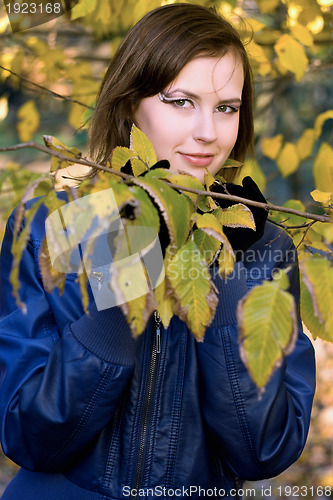 Image of smiling girl amongst the autumn leaves