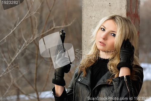 Image of Confused blonde girl with a gun