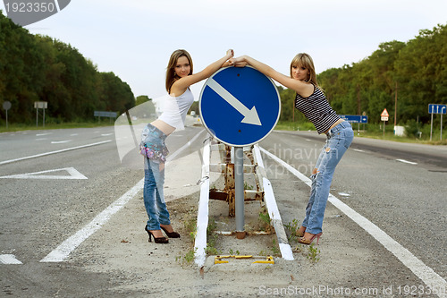Image of Two girls stand on a road
