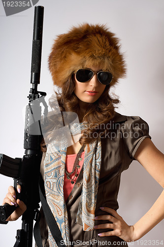 Image of Young stylish woman with a gun