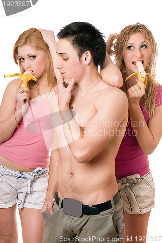 Image of Young man and two playful women with bananas