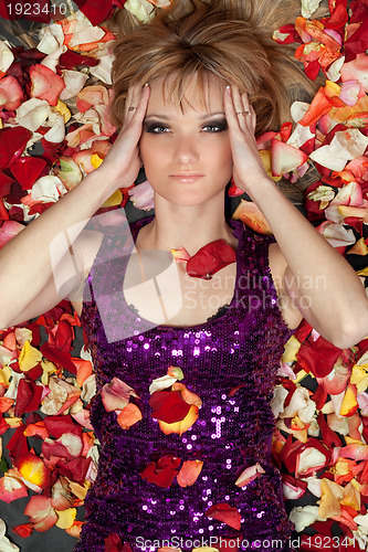 Image of lovely young blonde lying in rose petals