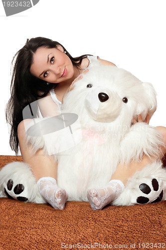 Image of Lovely girl sitting in an embrace with a teddy bear