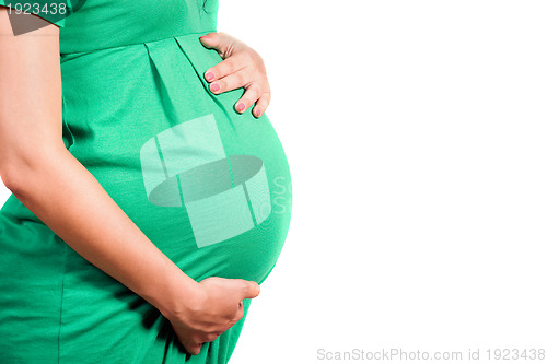 Image of Belly of a pregnant girl in green dress