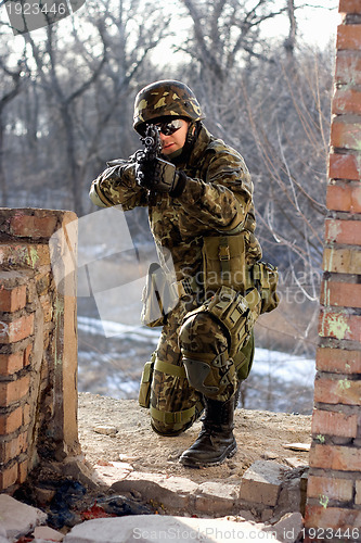 Image of Soldier sitting near wall with a gun