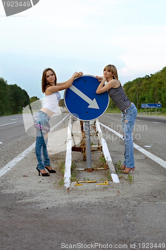 Image of Two pretty girls stand on a road