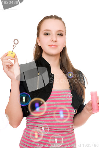 Image of Portrait of smiling young woman blow bubbles