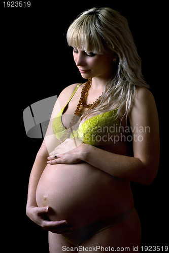 Image of Young pregnant woman in yellow lingerie. Isolated