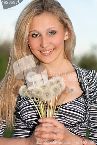 Image of attractive blonde with a dandelions