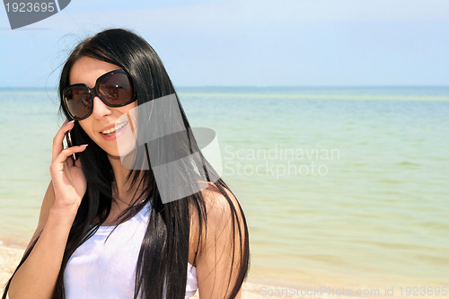 Image of smiling brunette speaking on the phone