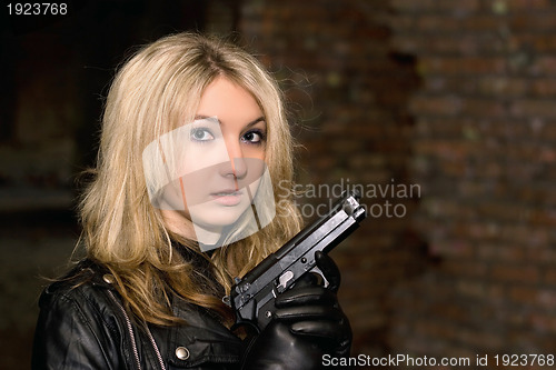 Image of Scared beautiful woman with a gun
