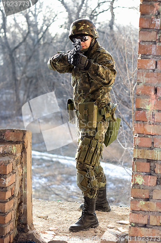 Image of Soldier near wall with a gun