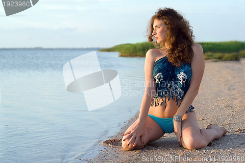 Image of Young woman sitting on the bay