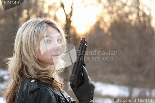 Image of Provocative young woman with a gun