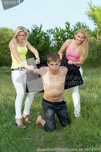 Image of Two playful blonde and young man outdoors