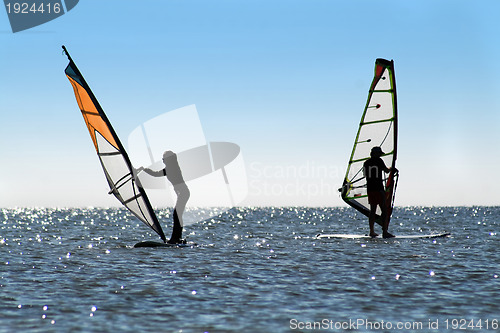 Image of Silhouette of a two windsurfers