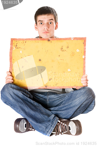 Image of Surprised young man holding yellow board