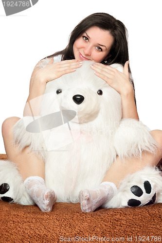 Image of Beautiful girl sitting in an embrace with a teddy bear