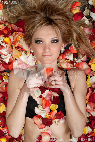 Image of  playful young blonde lying in rose petals