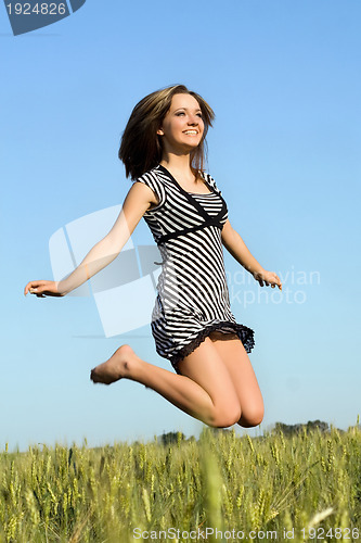 Image of pretty girl jumping in field