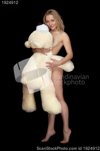 Image of Pretty naked young woman posing with large teddy bear