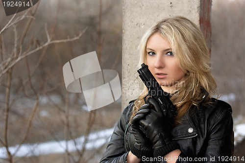 Image of Scared young woman with a weapon