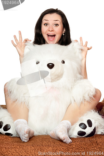Image of Cheerful girl plays with a teddy bear