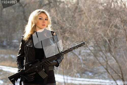 Image of attractive young blonde with a gun