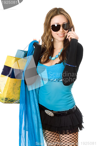 Image of Pretty young woman talking on the phone after shopping
