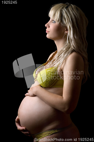 Image of Pregnant girl in yellow lingerie. Isolated