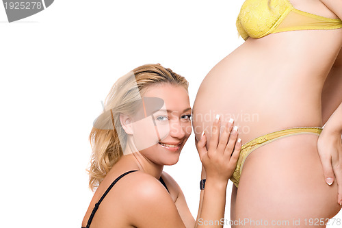 Image of Smiling woman and belly of pregnant girlfriend