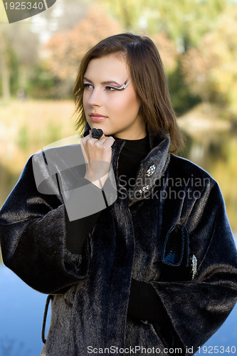 Image of  nice young woman in autumn park