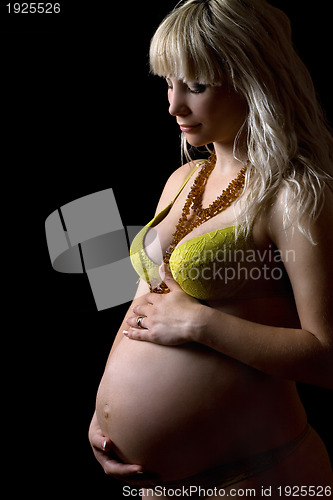 Image of Pregnant young woman in yellow lingerie. Isolated