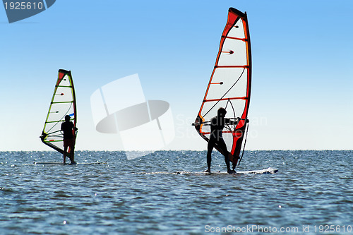 Image of Silhouette of a two windsurfers