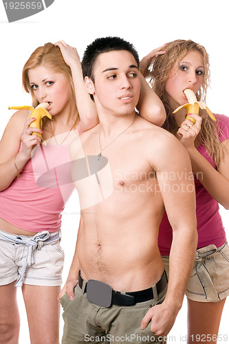 Image of Young man and two pretty women with bananas