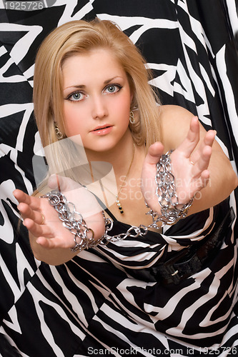 Image of attractive blonde stretches out her hands in chains
