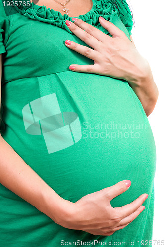 Image of Belly of a pregnant girl in green dress. Isolated