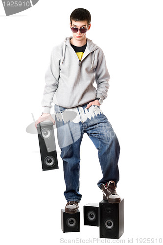 Image of Young man in sunglasses standing on the speakers