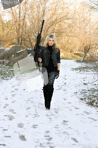 Image of Beautiful young blonde with a gun