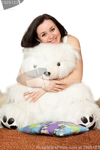 Image of Smiling girl sitting in an embrace with a teddy bear