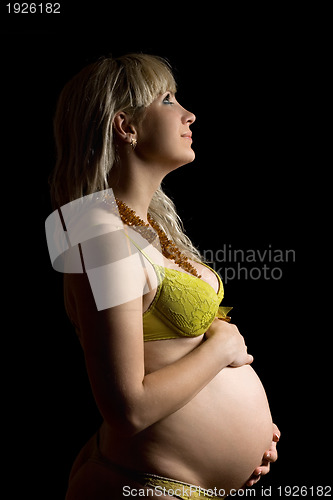 Image of Happy pregnant young woman in yellow lingerie. Isolated