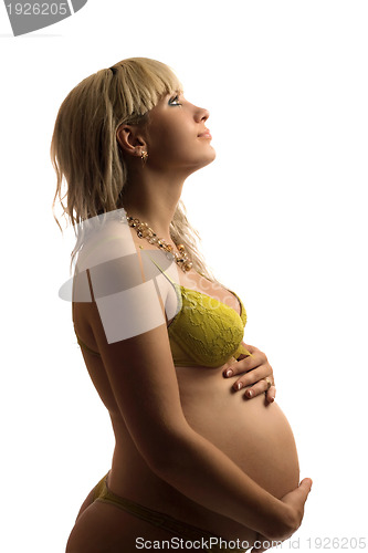 Image of Happy pregnant young woman in yellow lingerie