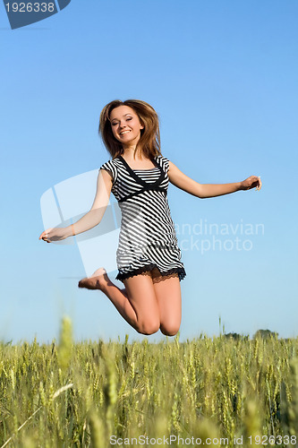 Image of attractive girl jumping in field